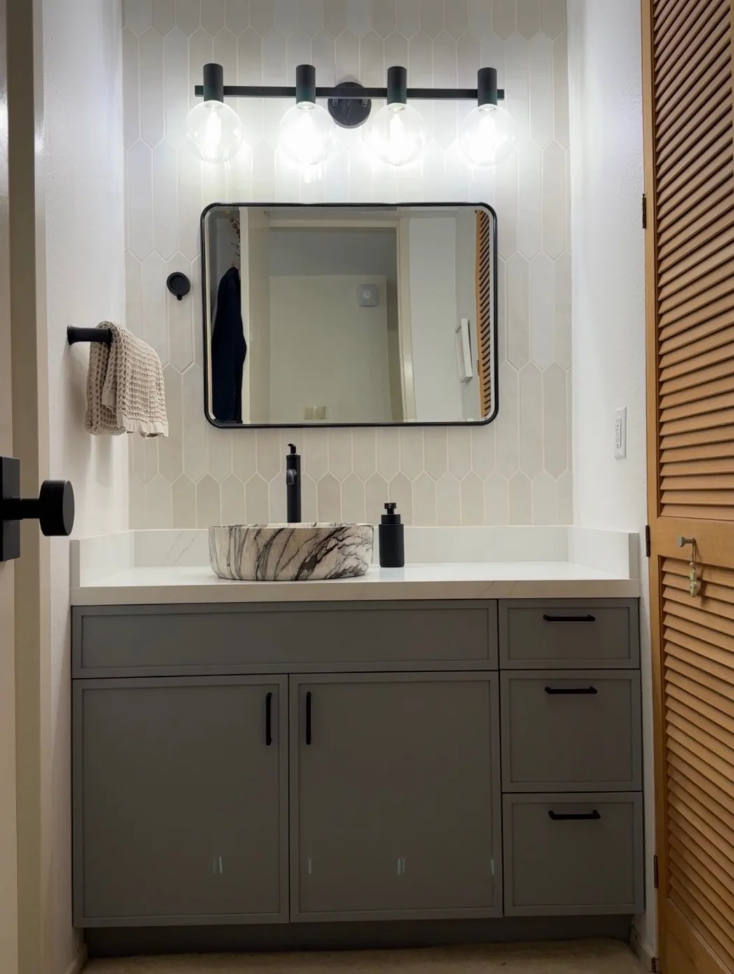 Powder room with cream picket tile and a stone vessel basin