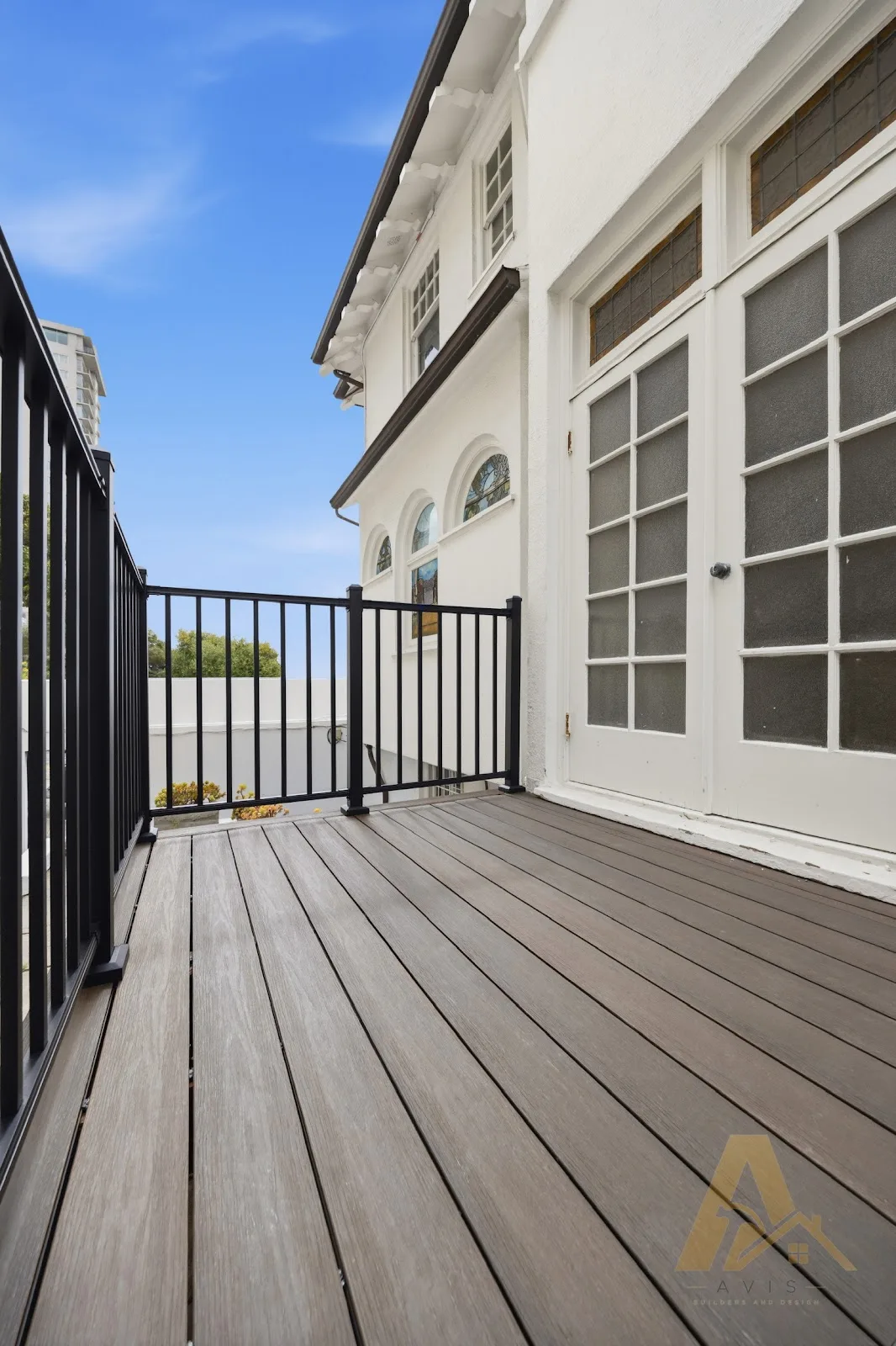 Gray composite deck and black railing beside French doors