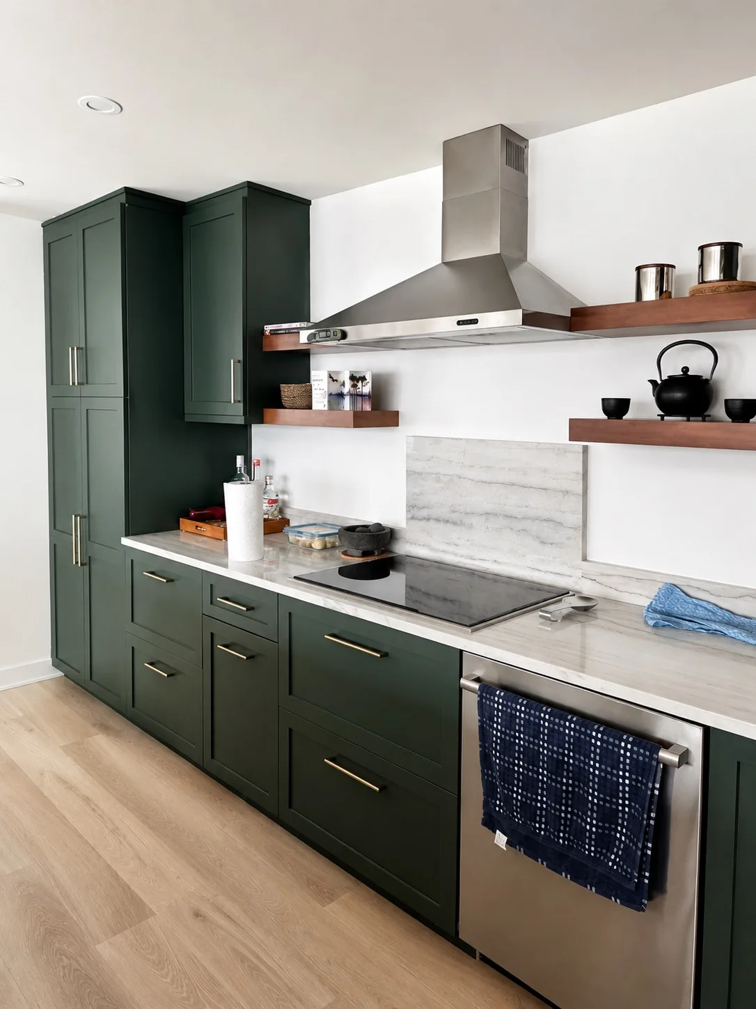 Dark green cabinets with a stainless hood and floating shelves