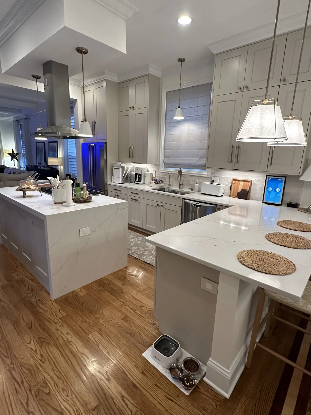 Greige shaker kitchen with a quartz waterfall island