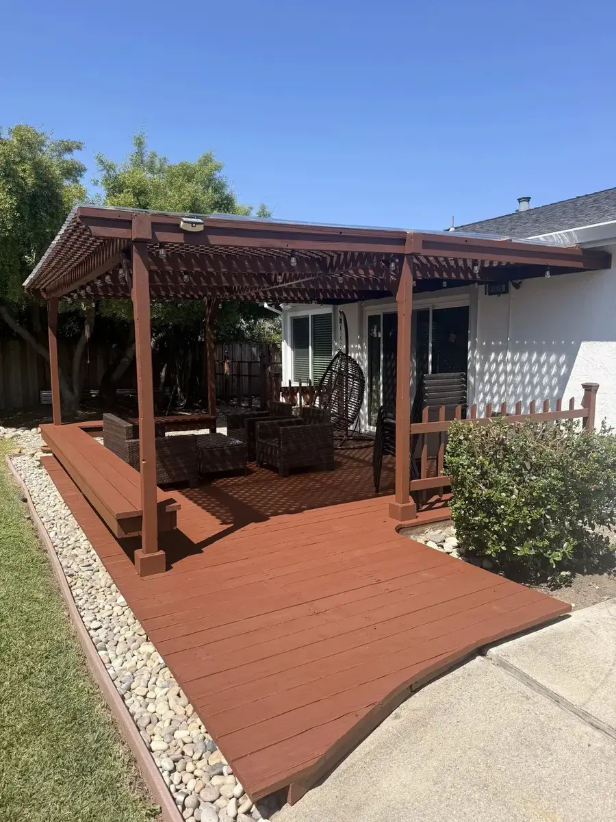 Stained wood pergola over an outdoor living deck